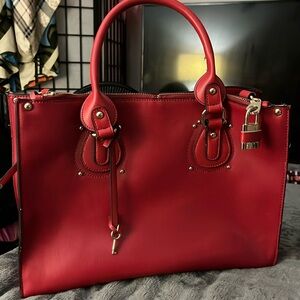 Vintage red leather handbag with chrome accents ie lock and key.